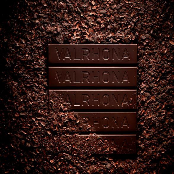 Valrhona Oqo Schokoladenblock vor Kakaoschalen Valrhona Oqo Schokoladenblock vor Kakaoschalen